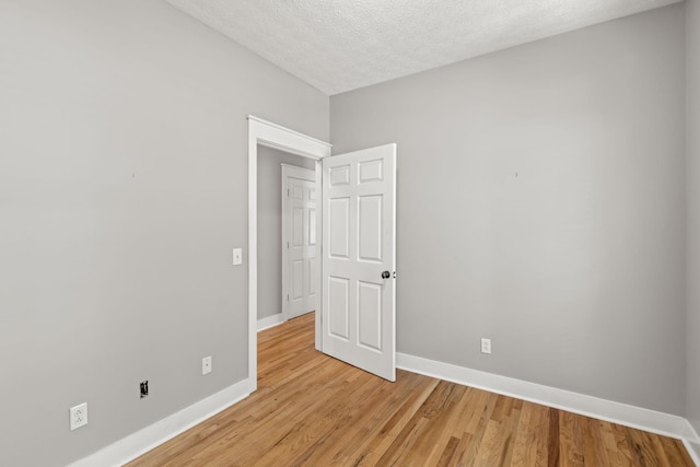 unfurnished bedroom with light hardwood / wood-style floors and a textured ceiling