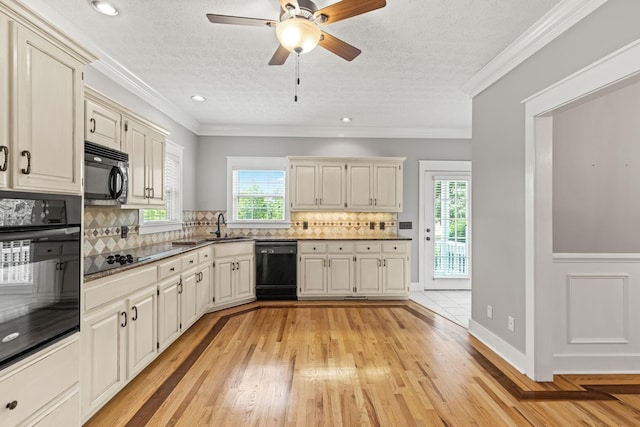 kitchen featuring plenty of natural light, black appliances, and light hardwood / wood-style floors