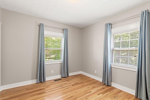 empty room featuring light hardwood / wood-style floors and a textured ceiling