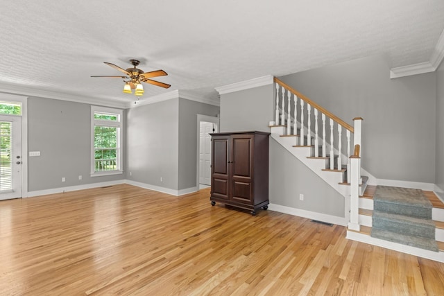 unfurnished living room featuring ceiling fan, light hardwood / wood-style flooring, crown molding, and a textured ceiling