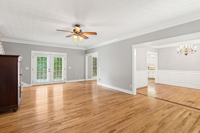 unfurnished living room featuring french doors, crown molding, a textured ceiling, ceiling fan with notable chandelier, and light wood-type flooring