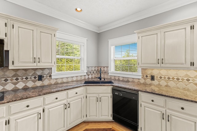 kitchen featuring backsplash, ornamental molding, dark stone counters, sink, and black dishwasher