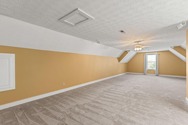 bonus room with lofted ceiling, light carpet, and a textured ceiling