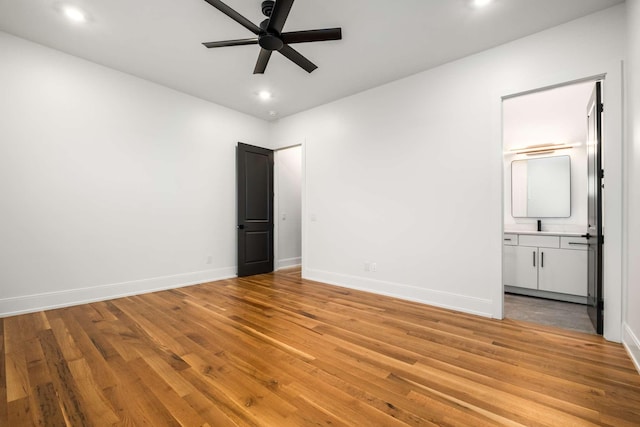 unfurnished bedroom with connected bathroom, ceiling fan, and light hardwood / wood-style floors