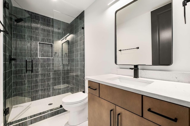 bathroom with tile patterned floors, vanity, toilet, and walk in shower