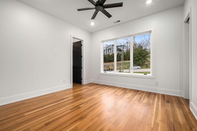 empty room with ceiling fan and light hardwood / wood-style floors