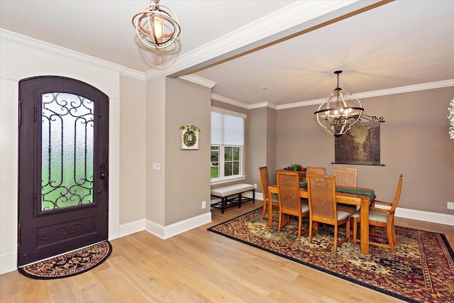 entrance foyer featuring hardwood / wood-style flooring, ornamental molding, and a chandelier