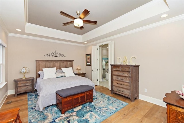 bedroom with a tray ceiling, light hardwood / wood-style flooring, ceiling fan, and crown molding