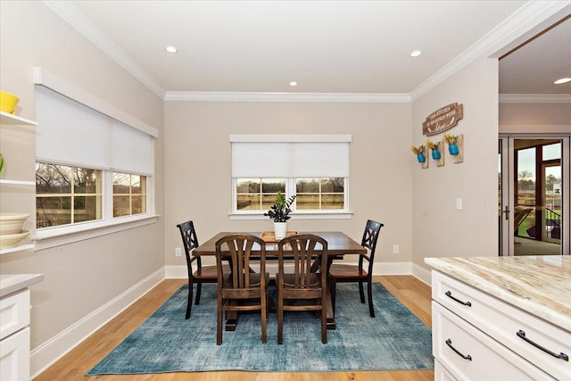 dining space with light hardwood / wood-style floors, plenty of natural light, and crown molding