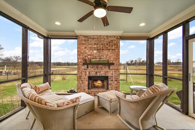 sunroom featuring a rural view, an outdoor brick fireplace, and ceiling fan