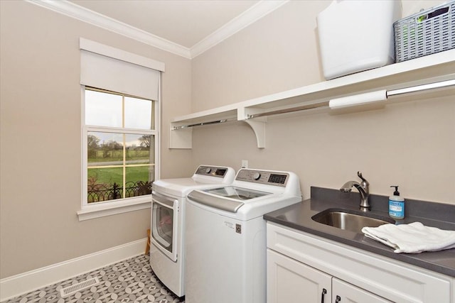 laundry area with cabinets, washing machine and dryer, crown molding, and sink