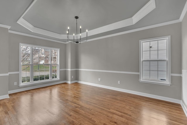 unfurnished room featuring crown molding, hardwood / wood-style floors, and an inviting chandelier