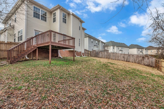 rear view of property featuring a deck and a yard