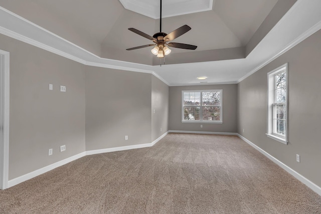 spare room with a tray ceiling, crown molding, ceiling fan, and light colored carpet