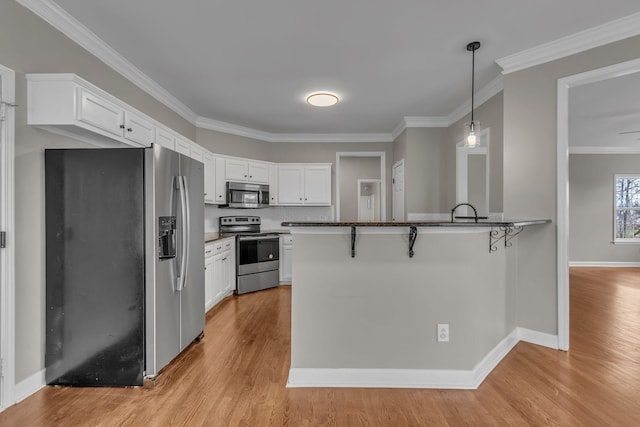 kitchen with a breakfast bar, white cabinets, and stainless steel appliances