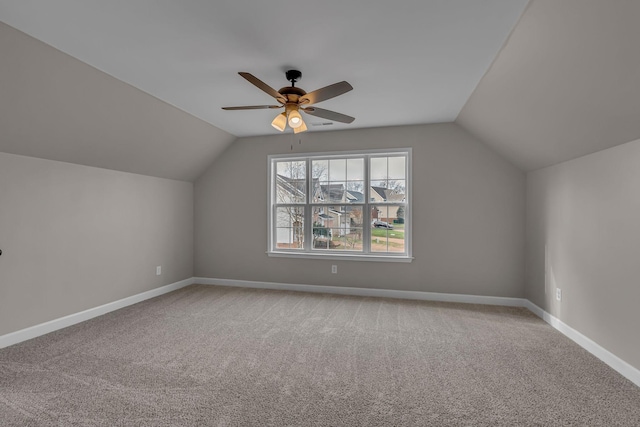 additional living space featuring light colored carpet, vaulted ceiling, and ceiling fan