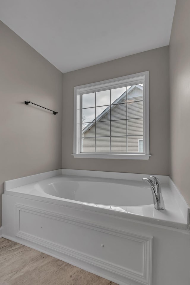 bathroom featuring a tub to relax in and wood-type flooring