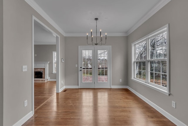 unfurnished dining area featuring hardwood / wood-style floors, a healthy amount of sunlight, and an inviting chandelier