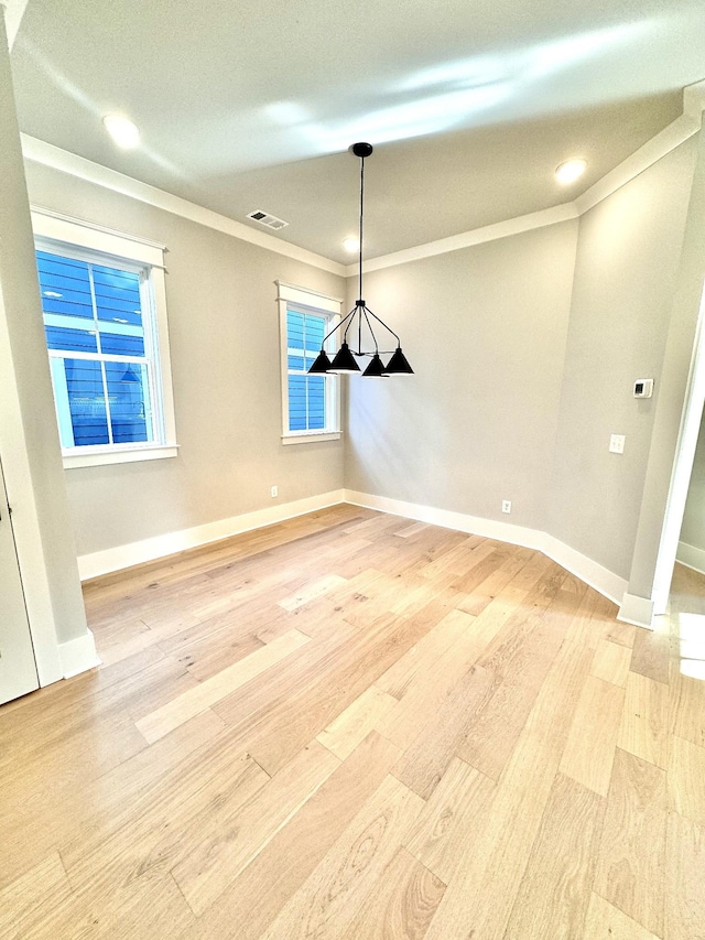 unfurnished dining area with ornamental molding and hardwood / wood-style floors