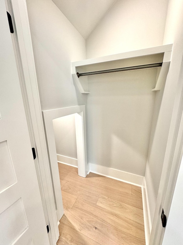 walk in closet with lofted ceiling and light wood-type flooring