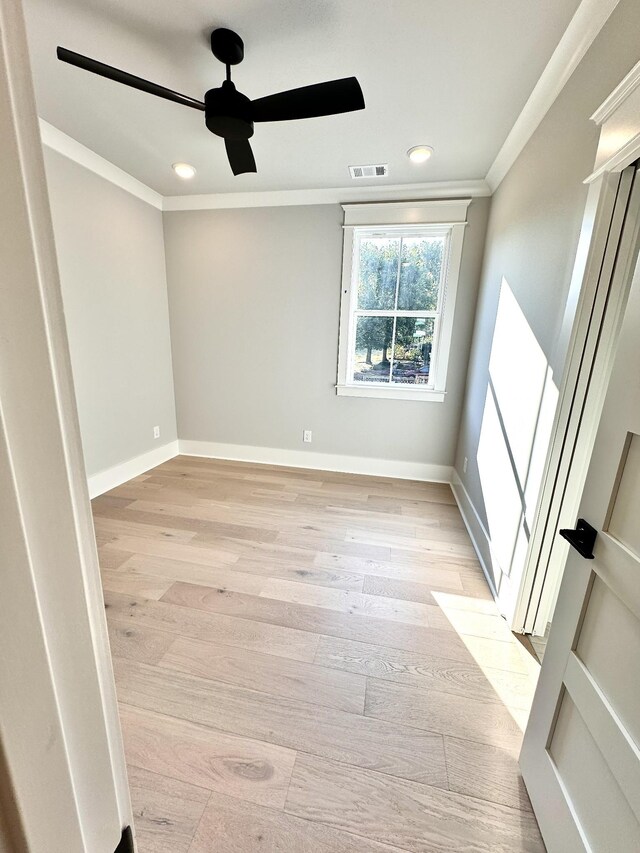 unfurnished room featuring ceiling fan, ornamental molding, and light wood-type flooring