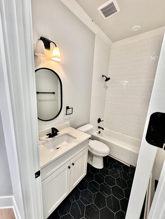 full bathroom featuring tiled shower / bath combo, vanity, tile patterned flooring, and toilet