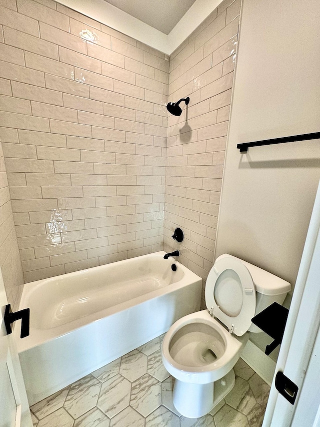 bathroom featuring tiled shower / bath combo and toilet