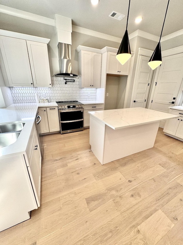 kitchen featuring white cabinetry, extractor fan, range with two ovens, and pendant lighting