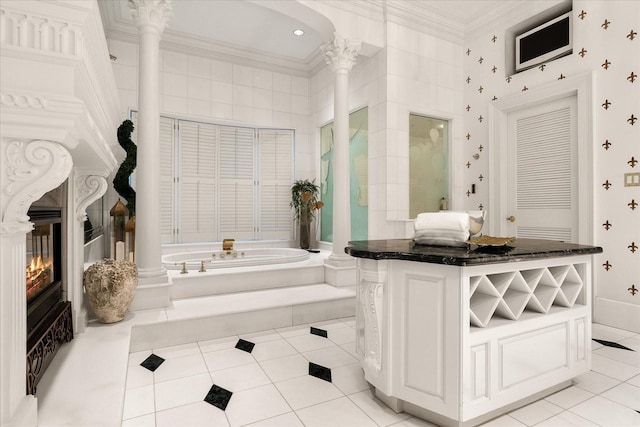 full bathroom with tile patterned flooring, a bath, a glass covered fireplace, decorative columns, and crown molding