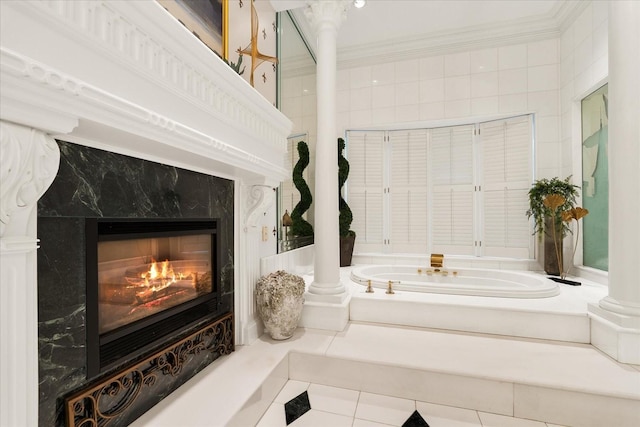 bathroom with a garden tub, crown molding, a fireplace, tile patterned flooring, and ornate columns