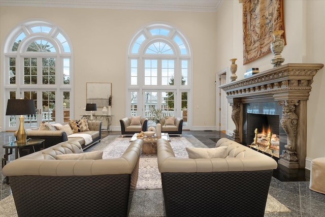 living room with french doors, granite finish floor, a towering ceiling, ornamental molding, and baseboards