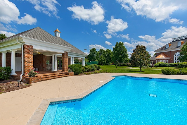 pool featuring a patio and a yard