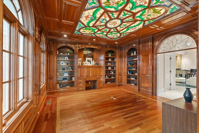 wine room with built in shelves, coffered ceiling, visible vents, and light wood-style floors