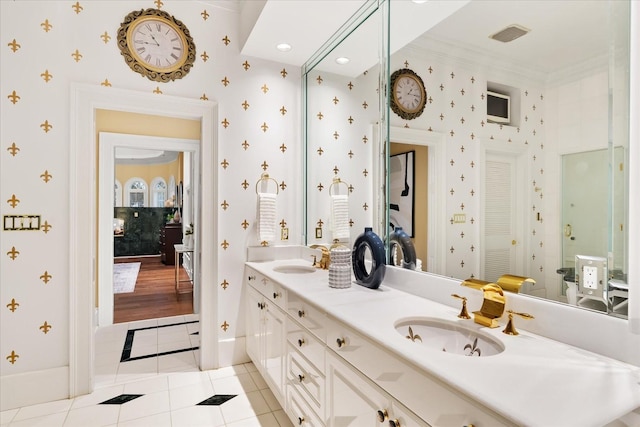 full bathroom with double vanity, wallpapered walls, tile patterned flooring, and a sink