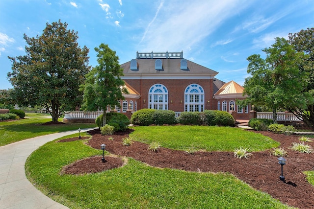 view of front of home with a front lawn and brick siding