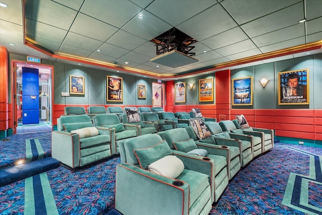 carpeted cinema room featuring a paneled ceiling