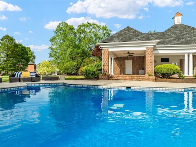 outdoor pool with ceiling fan and an outdoor living space