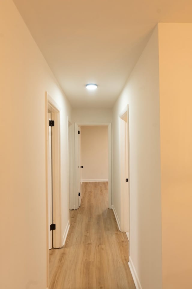 corridor with light hardwood / wood-style floors