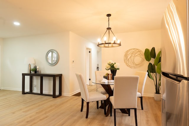 dining room with light hardwood / wood-style floors and a chandelier