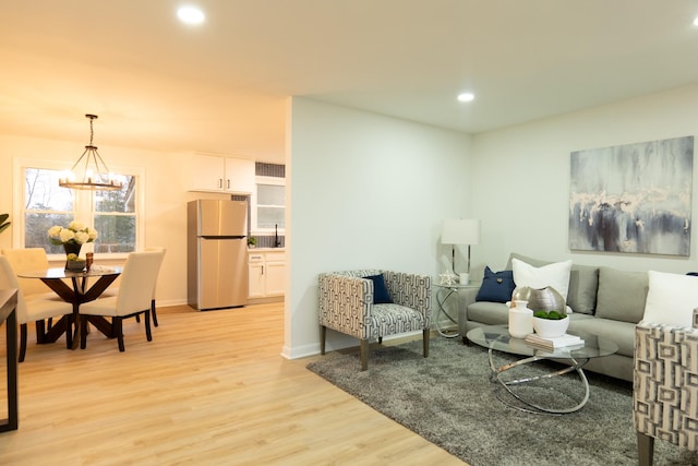 living room featuring light hardwood / wood-style flooring and a notable chandelier