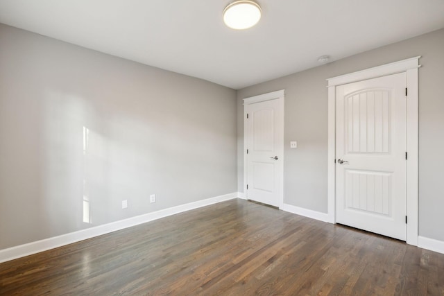 unfurnished bedroom with dark wood-type flooring