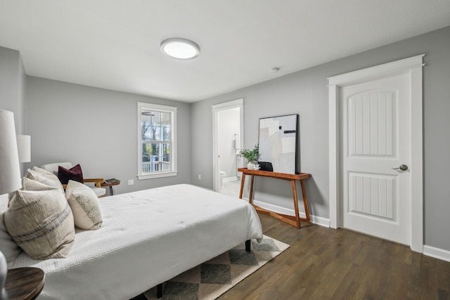 bedroom with dark hardwood / wood-style flooring and connected bathroom