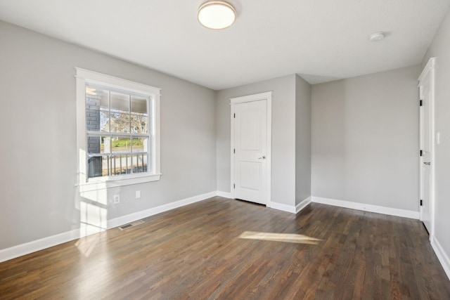 empty room with dark hardwood / wood-style floors