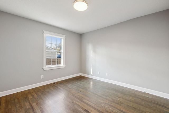 spare room featuring dark wood-type flooring