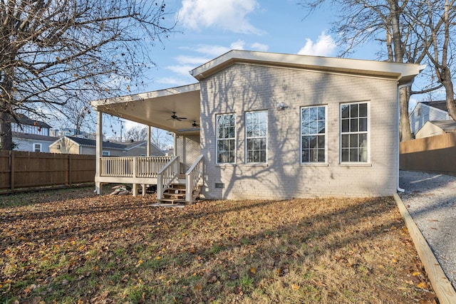 rear view of house featuring ceiling fan and a deck