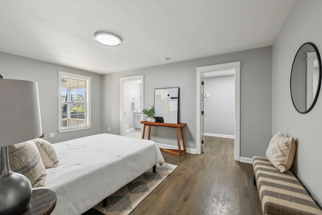 bedroom featuring ensuite bathroom and dark hardwood / wood-style flooring