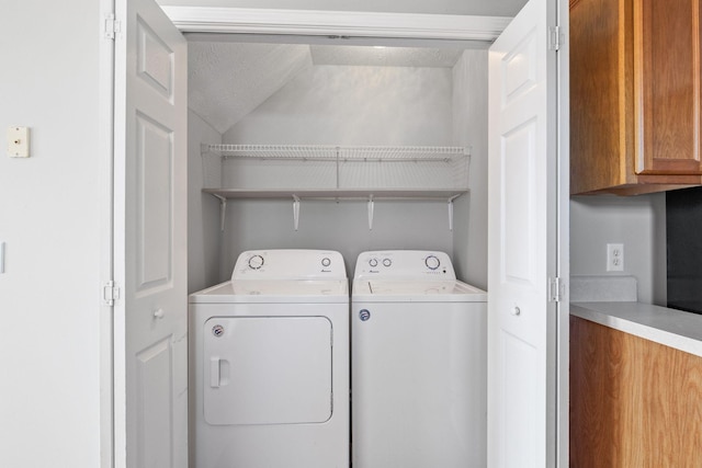 clothes washing area featuring separate washer and dryer and a textured ceiling