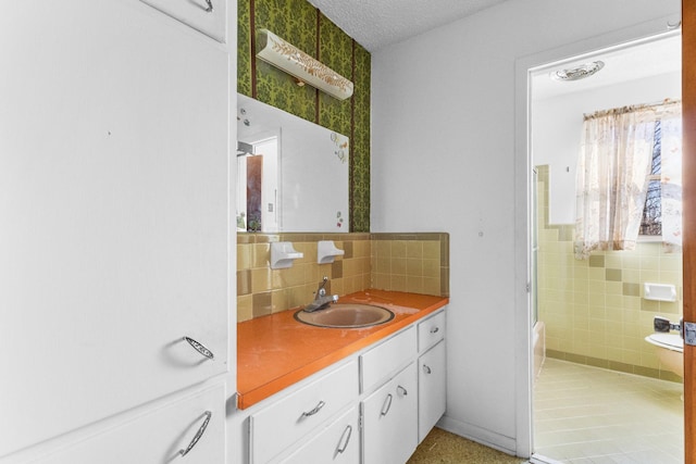 bathroom with vanity, a textured ceiling, tasteful backsplash, and toilet