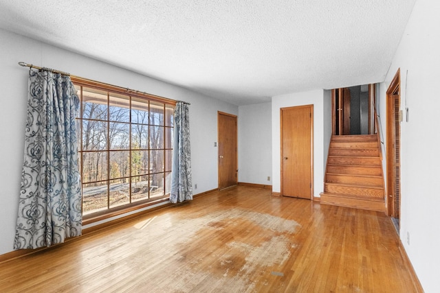 spare room featuring a textured ceiling and light hardwood / wood-style flooring