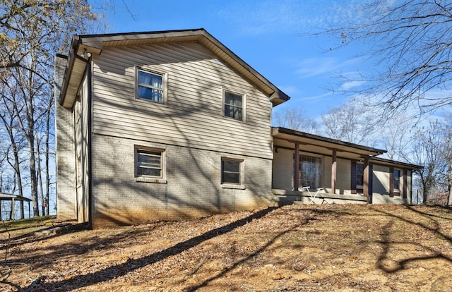 back of property featuring covered porch